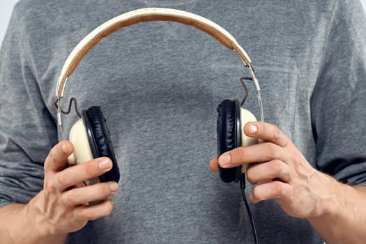 Man holding headphones in the hands of a man lifestyle modern style technology cropped view. High quality photo