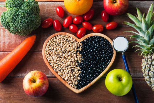 World food day, Top view of various fresh organic fruit and vegetable in heart plate and doctor stethoscope, studio shot on wooden table, Healthy vegetarian food concept