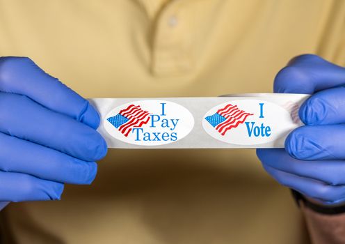 I Pay Taxes sticker on roll with voter campaign button for anger about the lack of federal tax paid by president in the presidential election
