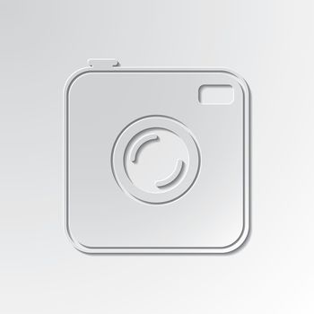 Old photocamera cut out icon on paper background.