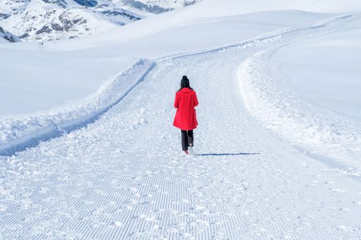 Young Woman Tourist walking in snow mountain Matterhorn peak, Zermatt, Switzerland.