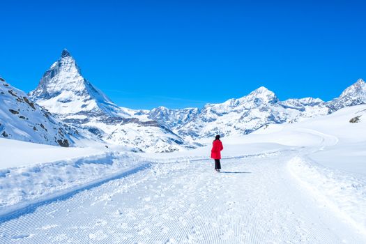 Young Woman Tourist see beautiful view of snow mountain Matterhorn peak, Zermatt, Switzerland.