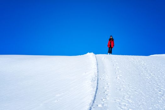 Young Woman Tourist walking in snow mountain Matterhorn peak, Zermatt, Switzerland.