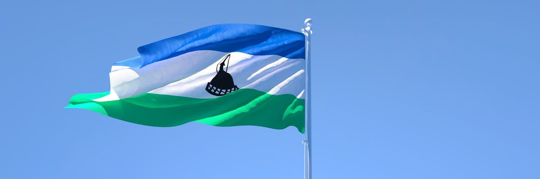 3D rendering of the national flag of Lesotho waving in the wind against a blue sky