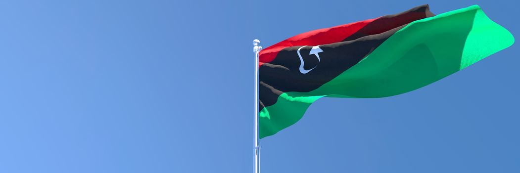 3D rendering of the national flag of Libya waving in the wind against a blue sky.