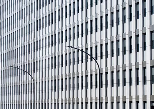 Line pattern of Architecture geometric. The perfect symmetry of the facade of an office building interrupted by the curved lines of two lampposts