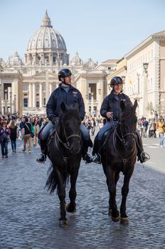 Rome, Italy. March 2019. Two Italian policemen on horseback in via della Conciliazione. In the background the Basilica