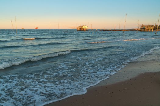 Fishing huts with typical italian fishing machine called trabucco ,at wonderful sunset .Lido di Dante, fiumi uniti Ravenna near Comacchio valley.