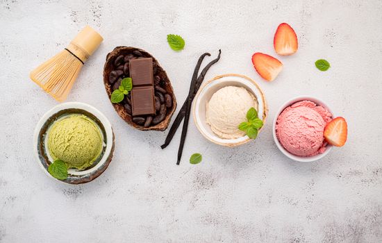 Various of ice cream  flavours in bowl blueberry ,green tea ,coconut ,strawberry and chocolate  setup on white stone background .