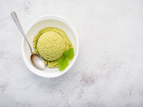 Matcha green tea ice cream with matcha whisk brush  setup on white stone background . Summer and Sweet menu concept.