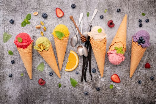Various of ice cream flavor in cones blueberry ,green tea ,pistachio ,almond ,orange and cherry setup on dark stone background . Summer and Sweet menu concept.