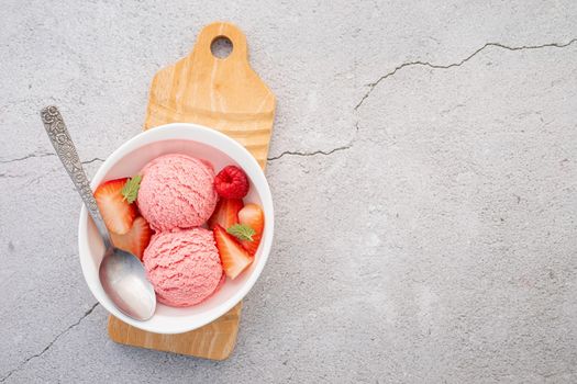 Strawberry  ice cream flavour in white  bowl setup on concrete background . Summer and Sweet menu concept.