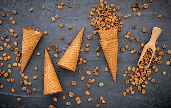 Flat lay coffee ice cream in waffle cone on dark stone background . Homemade coffee ice cream  with coffee beans for sweets menu design.
