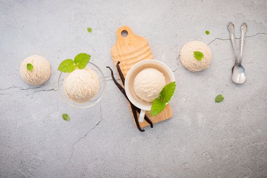 Vanilla ice cream flavor in bowl with vanilla pods setup on concrete background . Summer and Sweet menu concept.