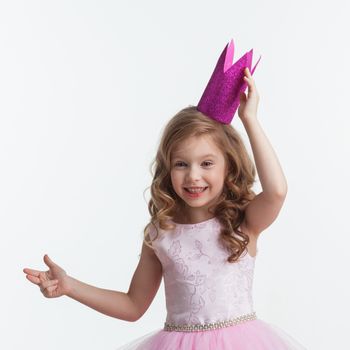 Little cute girl posing in pink halloween princess costume and crown isolated on white background