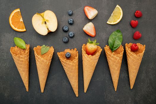 Various of fruits  in cones blueberry ,strawberry ,raspberries and orange setup on white stone background.  Summer and Sweet menu concept.