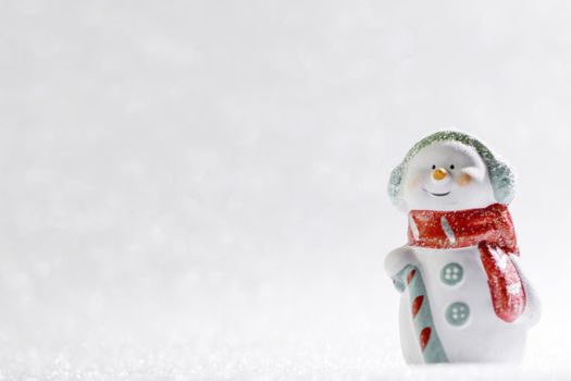 Christmas background of silver bokeh lights with cute toy snowman