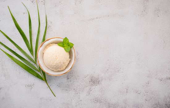 Coconut ice cream flavours in half of coconut setup on white stone background. Summer and Sweet menu concept.