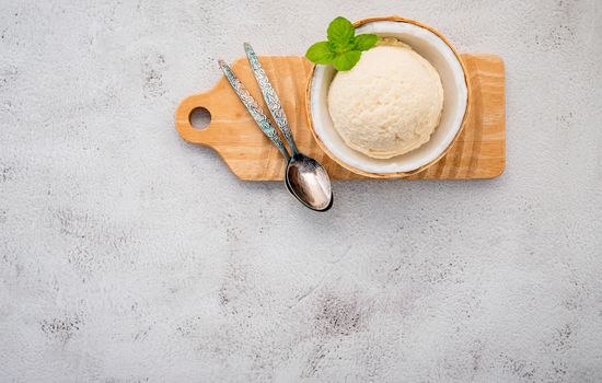 Coconut ice cream flavours in half of coconut setup on white stone background. Summer and Sweet menu concept.