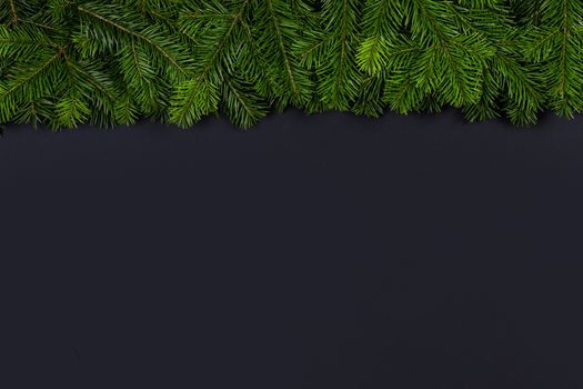 Christmas fir tree branch border fame on black paper stylish background with copy space for text