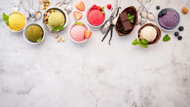 Various of ice cream  flavours in bowl blueberry ,green tea ,coconut ,strawberry and chocolate  setup on white stone background .