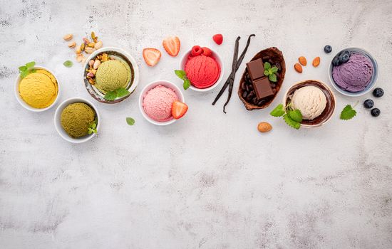 Various of ice cream  flavours in bowl blueberry ,green tea ,coconut ,strawberry and chocolate  setup on white stone background .