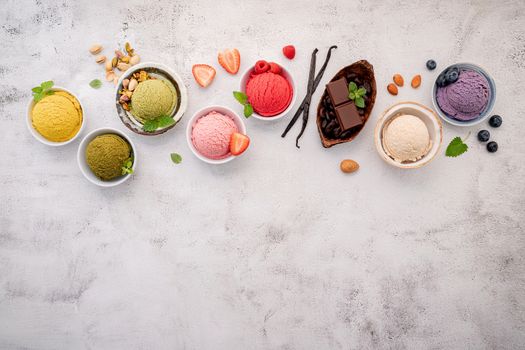 Various of ice cream  flavours in bowl blueberry ,green tea ,coconut ,strawberry and chocolate  setup on white stone background .