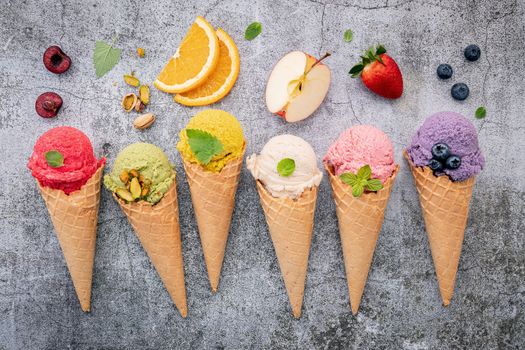 Various of ice cream flavor in cones blueberry ,green tea ,pistachio ,almond ,orange and cherry setup on dark stone background . Summer and Sweet menu concept.