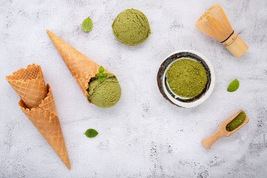 Matcha green tea ice cream with waffle cone and mint leaves  setup on white stone background . Summer and Sweet menu concept.