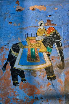 Mural of Maharajah on elephant on blue house wall in Jodhpur also known as Blue City due to the vivid blue-painted Brahmin houses. Johdpur, Rajasthan, India