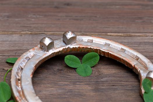 clover leaves and golden horseshoe on vintage wooden boards, selective focus. Good luck symbol, St. Patrick's Day and New Year concept.