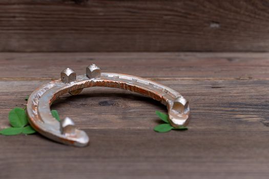 clover leaves and golden horseshoe on vintage wooden boards, selective focus. Good luck symbol, St. Patrick's Day and New Year concept.