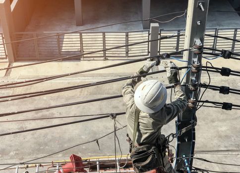 Electricians are climbing on electric poles to install power lines.