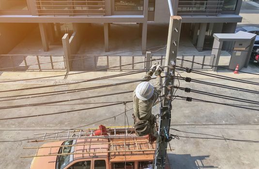 Electricians are climbing on electric poles to install power lines.