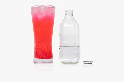 Glass of red nectar mixed with soda and soda bottles that open the lid on white background.