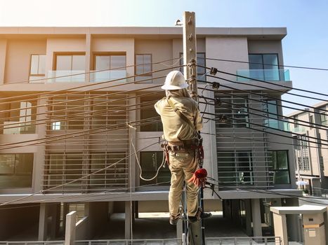 Electricians are climbing on electric poles to install power lines.