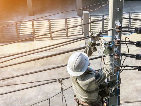 Electricians are climbing on electric poles to install power lines.