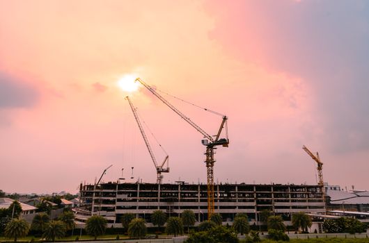 Heavy lifting cranes are important machinery and tools in the construction industry, with beautiful sky in the twilight time.