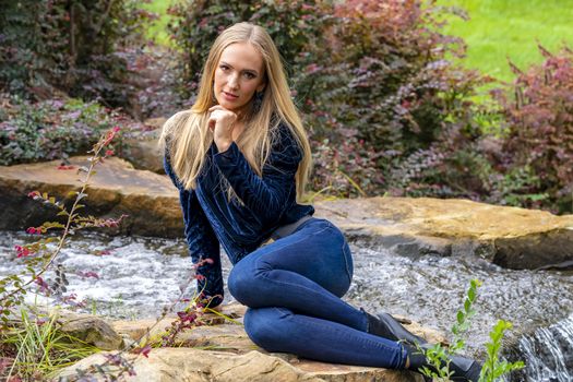 A gorgeous blonde model poses outdoors in her fall clothes