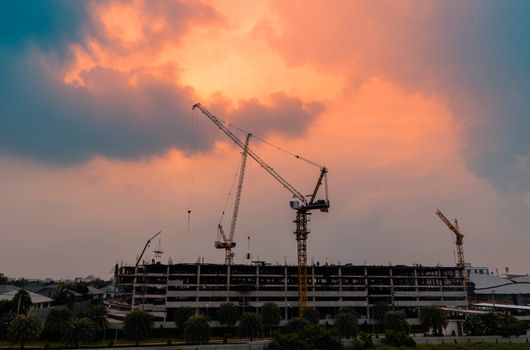 Heavy lifting cranes are important machinery and tools in the construction industry, with beautiful sky in the twilight time.