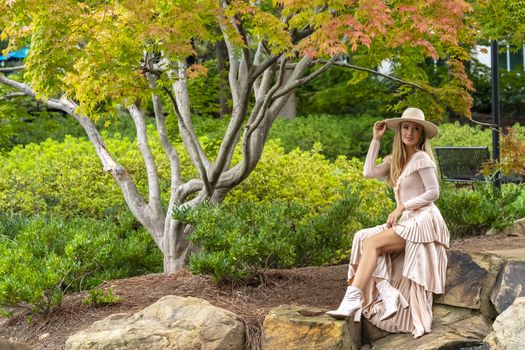 A gorgeous blonde model poses outdoors in her fall clothes