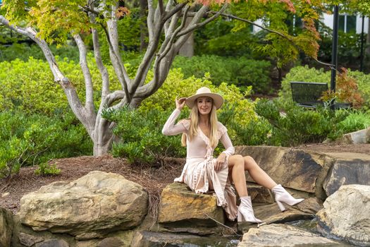 A gorgeous blonde model poses outdoors in her fall clothes