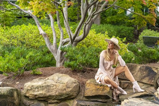 A gorgeous blonde model poses outdoors in her fall clothes