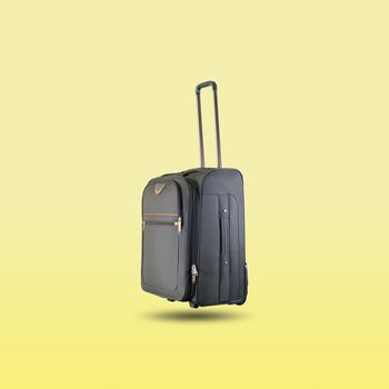 Black suitcase isolated on beautiful pastel color background, with clipping path.