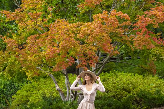 A gorgeous blonde model poses outdoors in her fall clothes