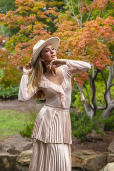 A gorgeous blonde model poses outdoors in her fall clothes