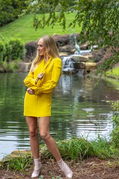 A gorgeous blonde model poses outdoors in her fall clothes