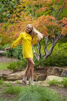 A gorgeous blonde model poses outdoors in her fall clothes