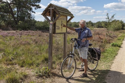 Bergen,holland,10-sep-2020:man on an ebike is looking for information about the Maasduinen nature reserve in Limburg