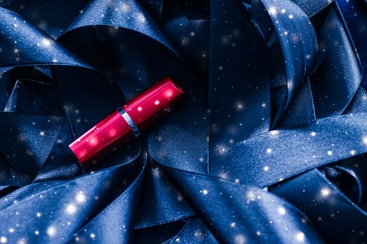 Red lipstick on blue silk and shiny glitter background, luxury make-up and beauty cosmetics